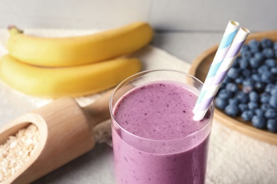 Photo of Glass with blueberry smoothie on table, closeup