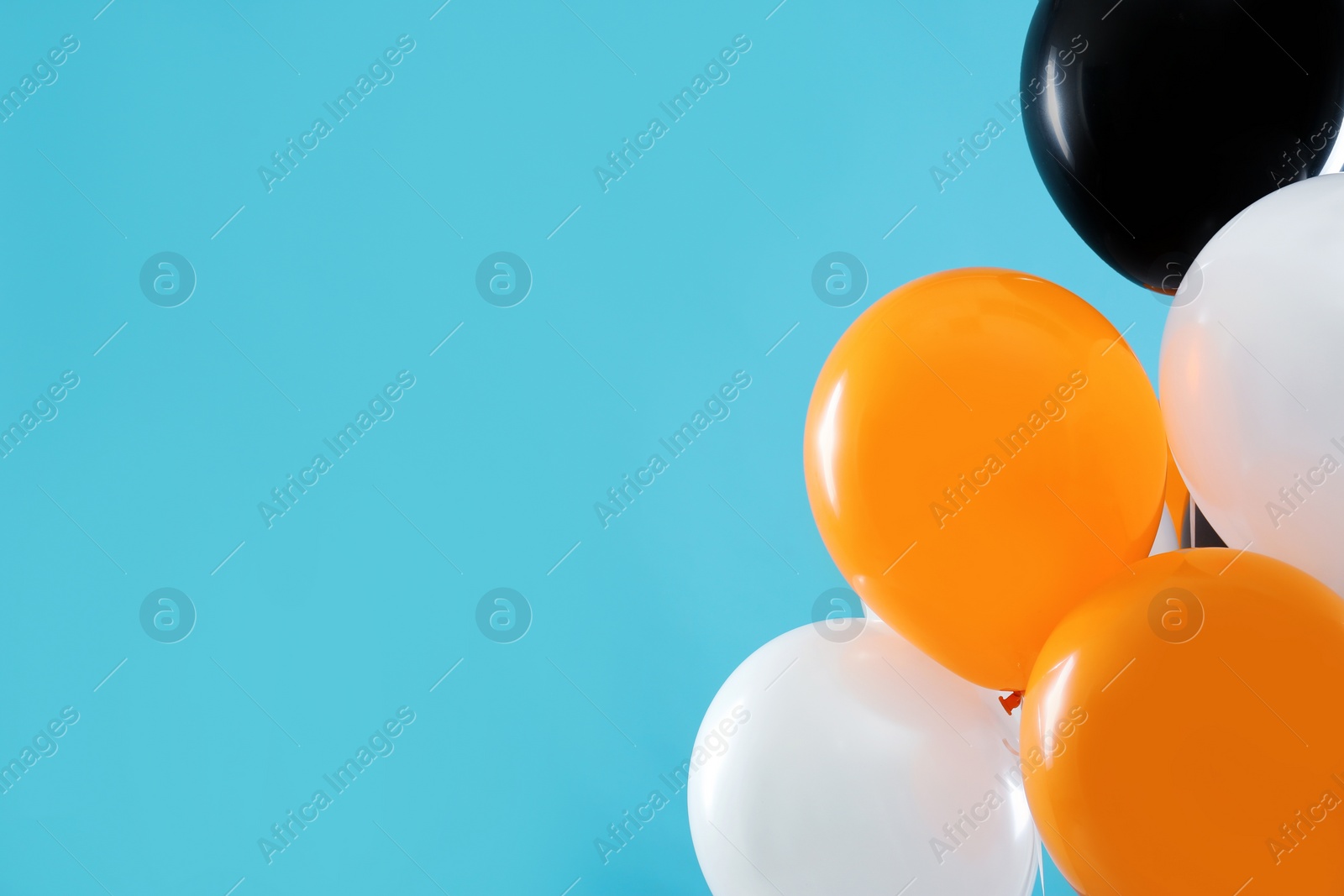 Photo of Colorful balloons on blue background, space for text. Halloween party