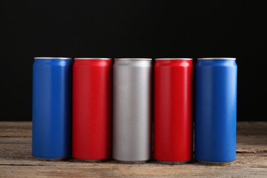 Energy drinks in colorful cans on wooden table