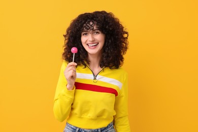 Photo of Beautiful woman with lollipop on yellow background