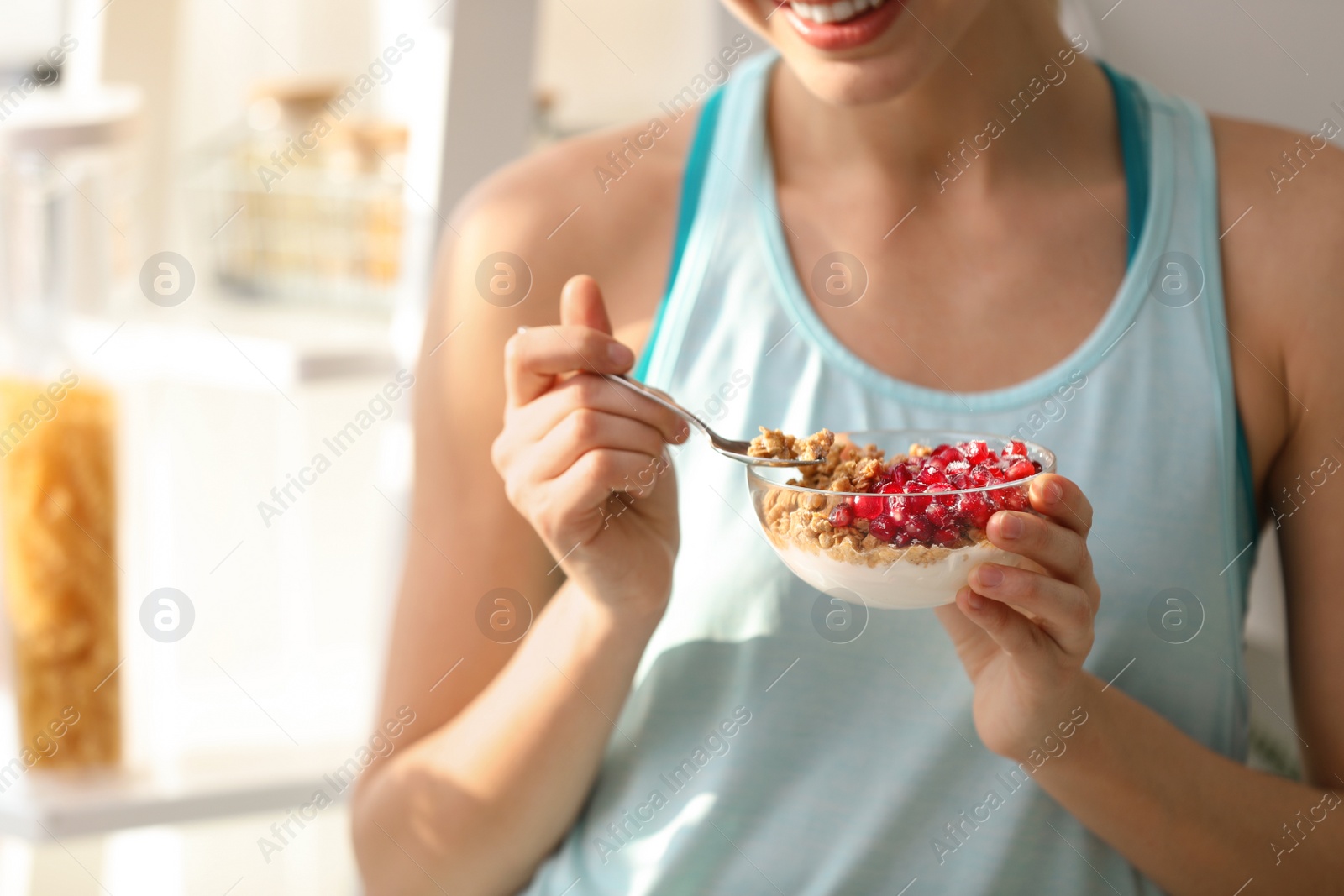 Photo of Young woman in fitness clothes having healthy breakfast at home, closeup