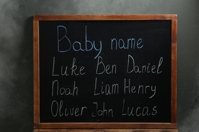 Photo of Blackboard with baby names near dark wall