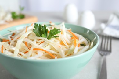 Photo of Tasty salad with cabbage and carrot on light grey table, closeup
