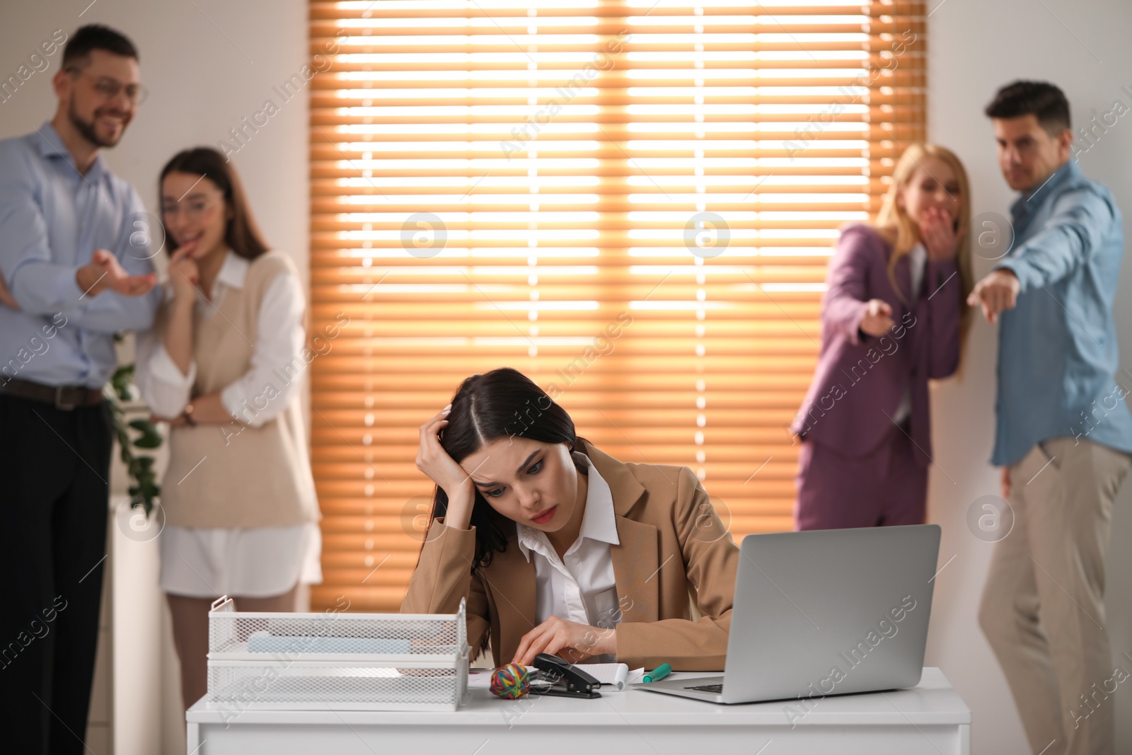 Photo of Coworkers bullying their colleague at workplace in office