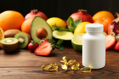 Photo of Vitamin pills, bottle and fresh fruits on wooden table. Space for text