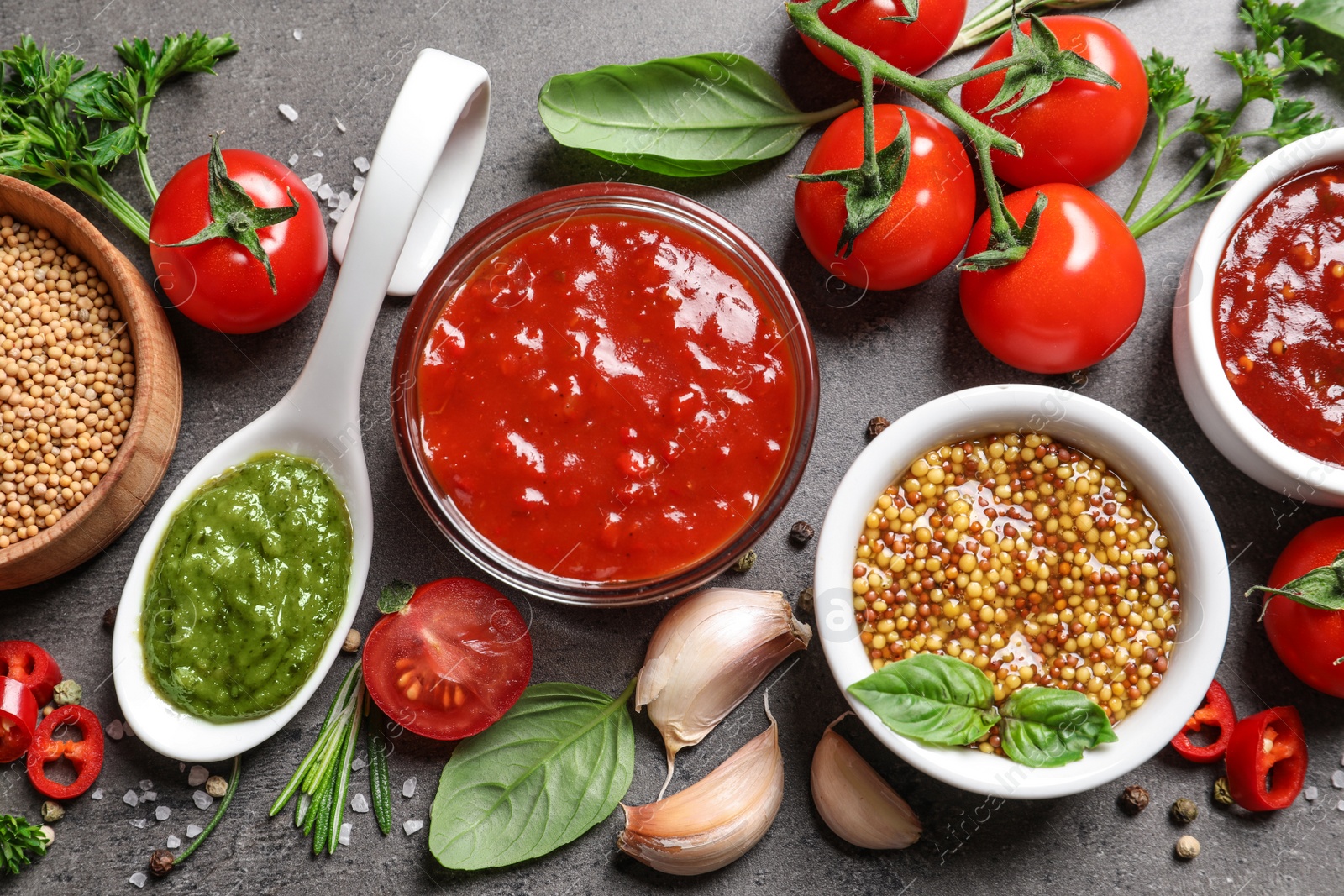 Photo of Flat lay composition with different sauces and ingredients on gray background