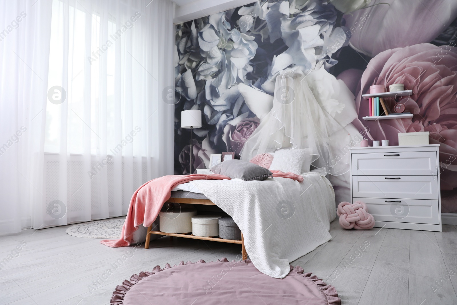 Photo of Teenage girl's room interior with comfortable bed and floral wallpaper. Idea for stylish design