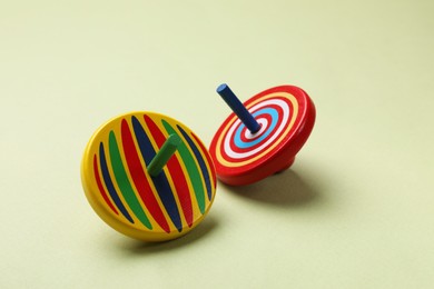 Two colorful spinning tops on green background