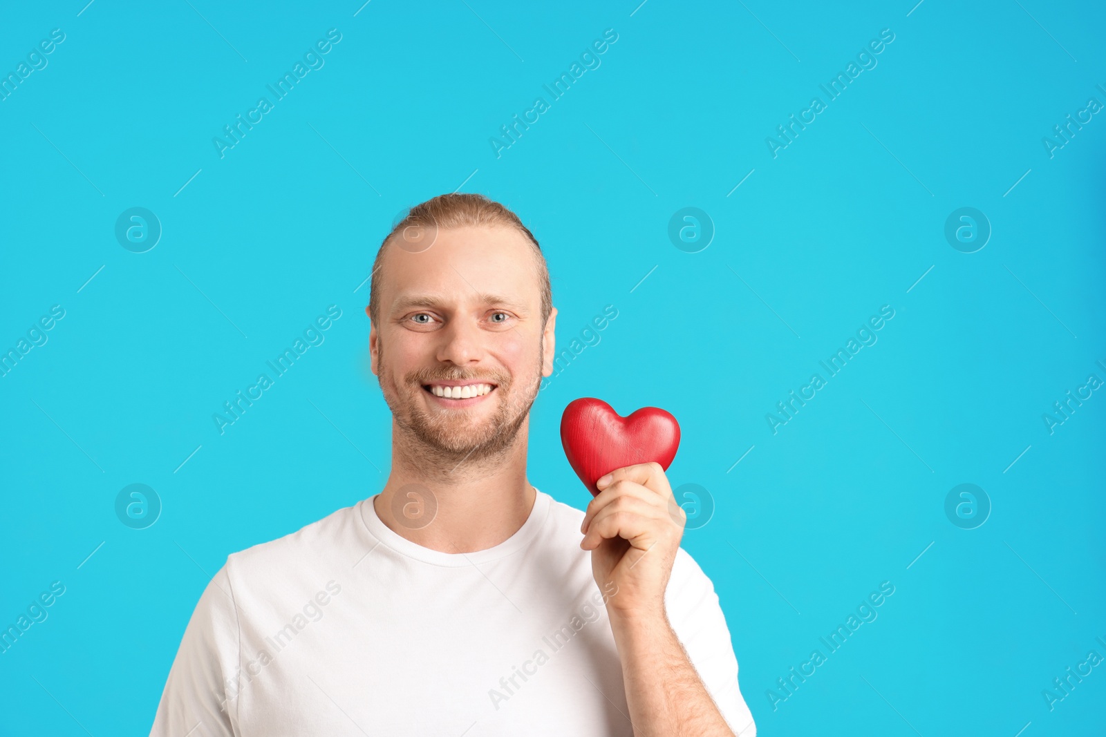 Photo of Portrait of man with decorative heart on color background. Space for text