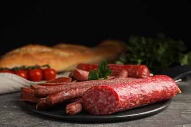 Photo of Different tasty sausages on grey table, closeup