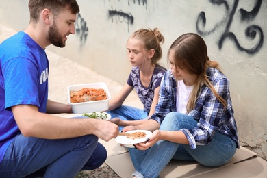 Poor people receiving food from volunteer outdoors