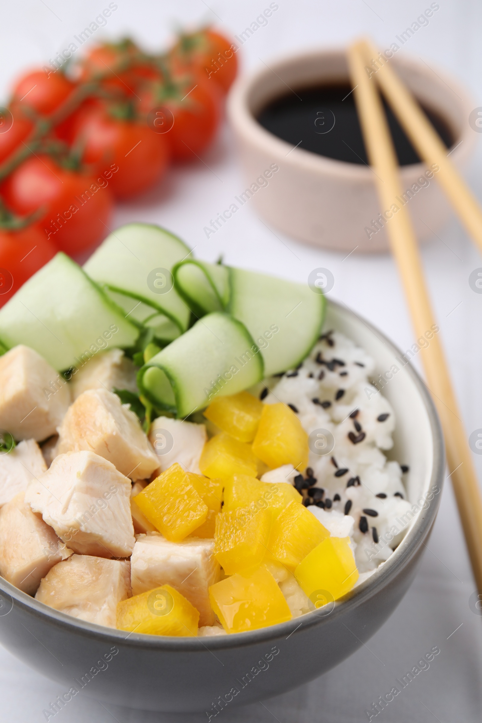 Photo of Delicious poke bowl with meat, rice and vegetables served on white table, closeup