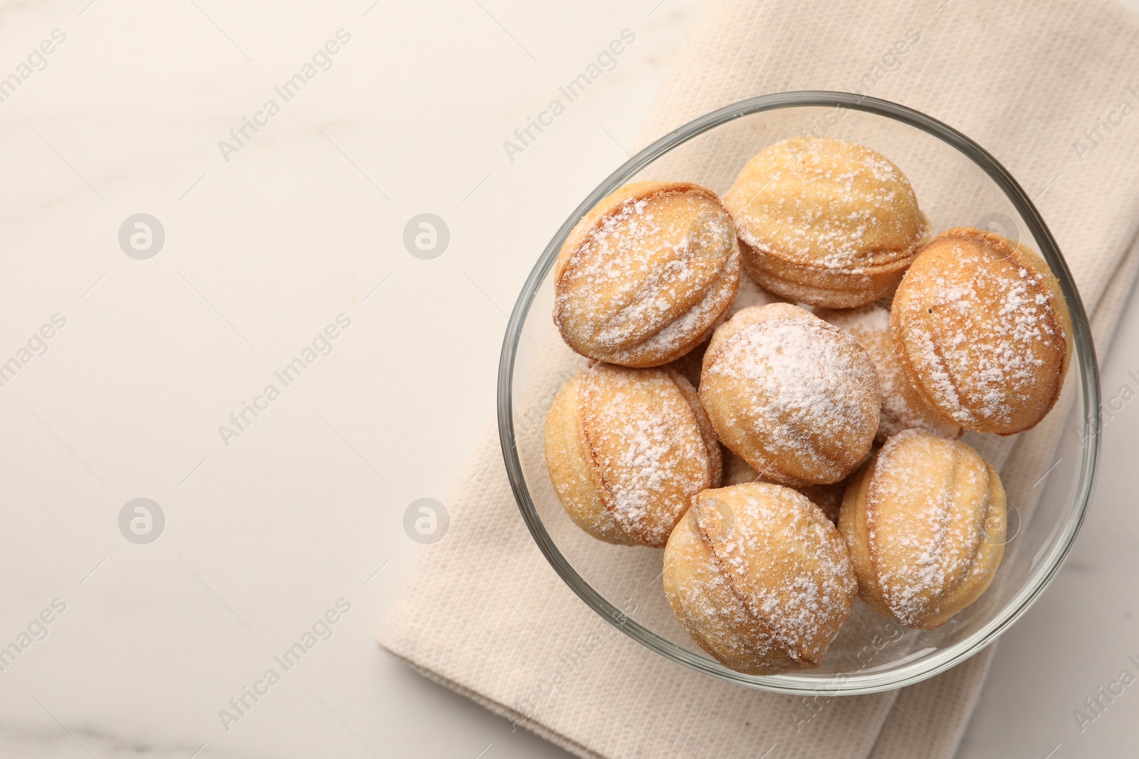 Photo of Homemade walnut shaped cookies with condensed milk on white marble table, top view. Space for text