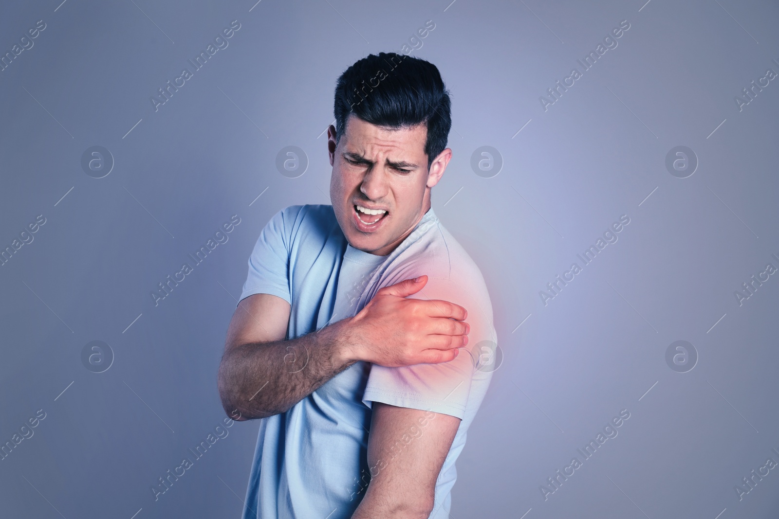 Image of Man suffering from shoulder pain on grey background