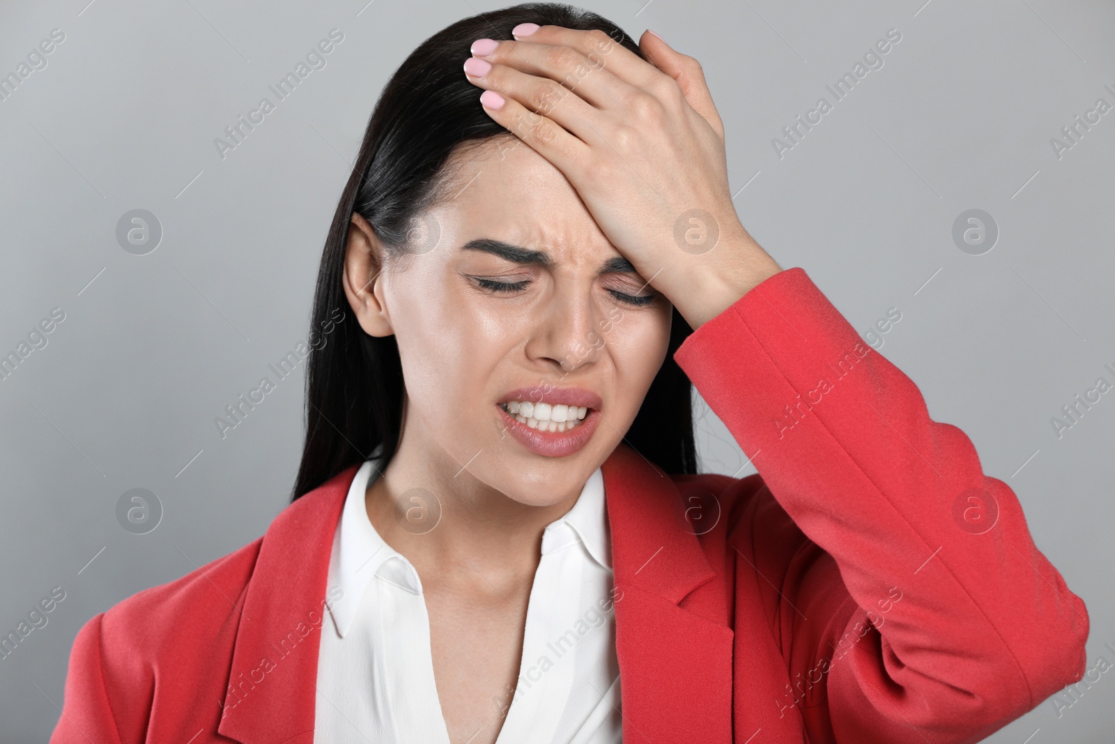 Photo of Woman suffering from migraine on grey background