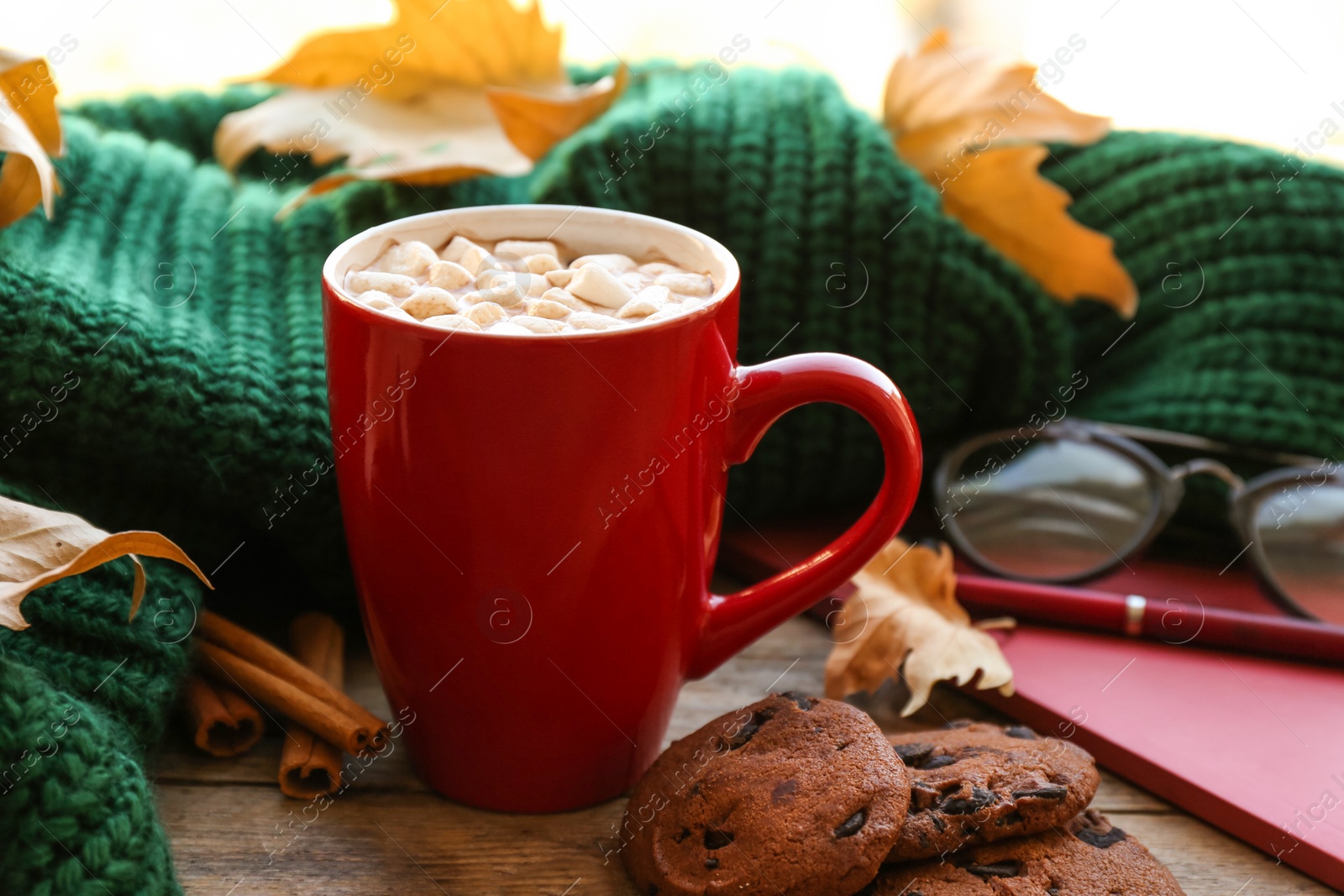 Photo of Composition with cup of hot drink, sweater and autumn leaves on windowsill. Cozy atmosphere