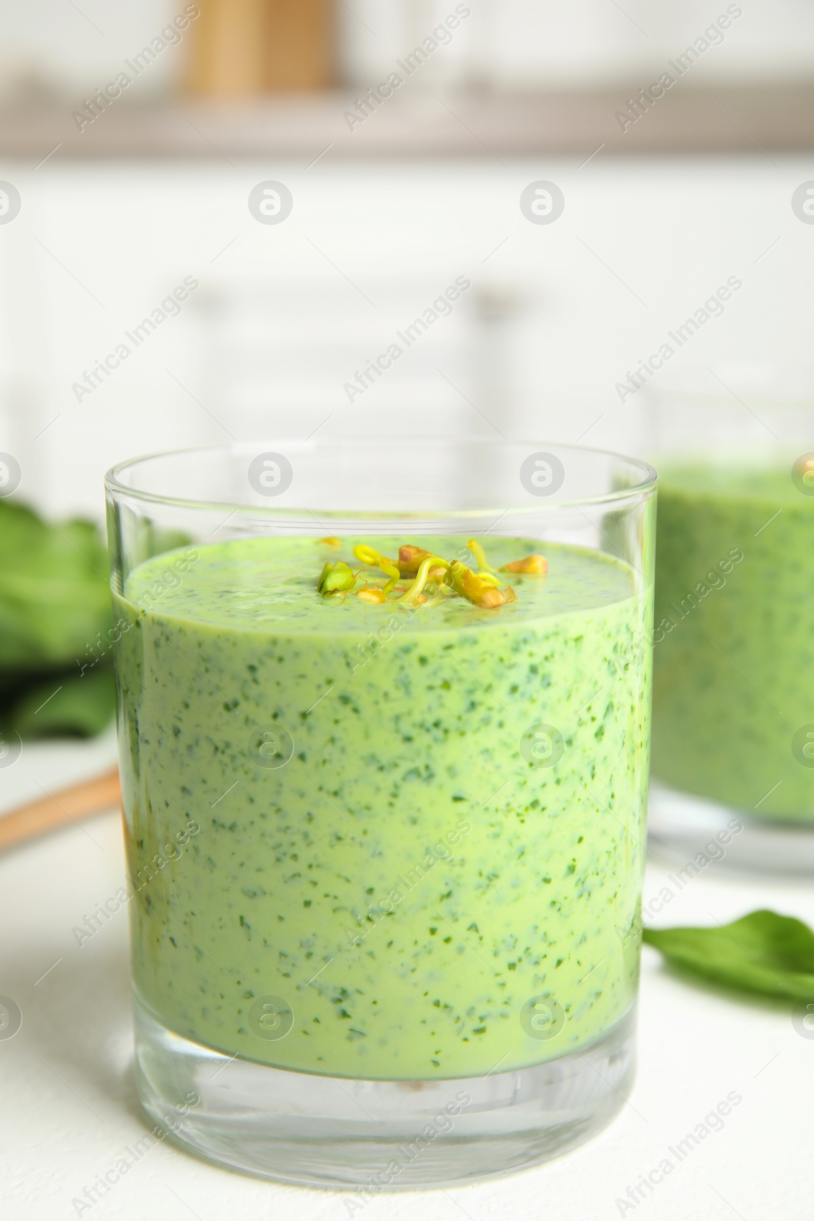 Photo of Green buckwheat smoothie on white table, closeup