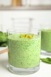 Photo of Green buckwheat smoothie on white table, closeup