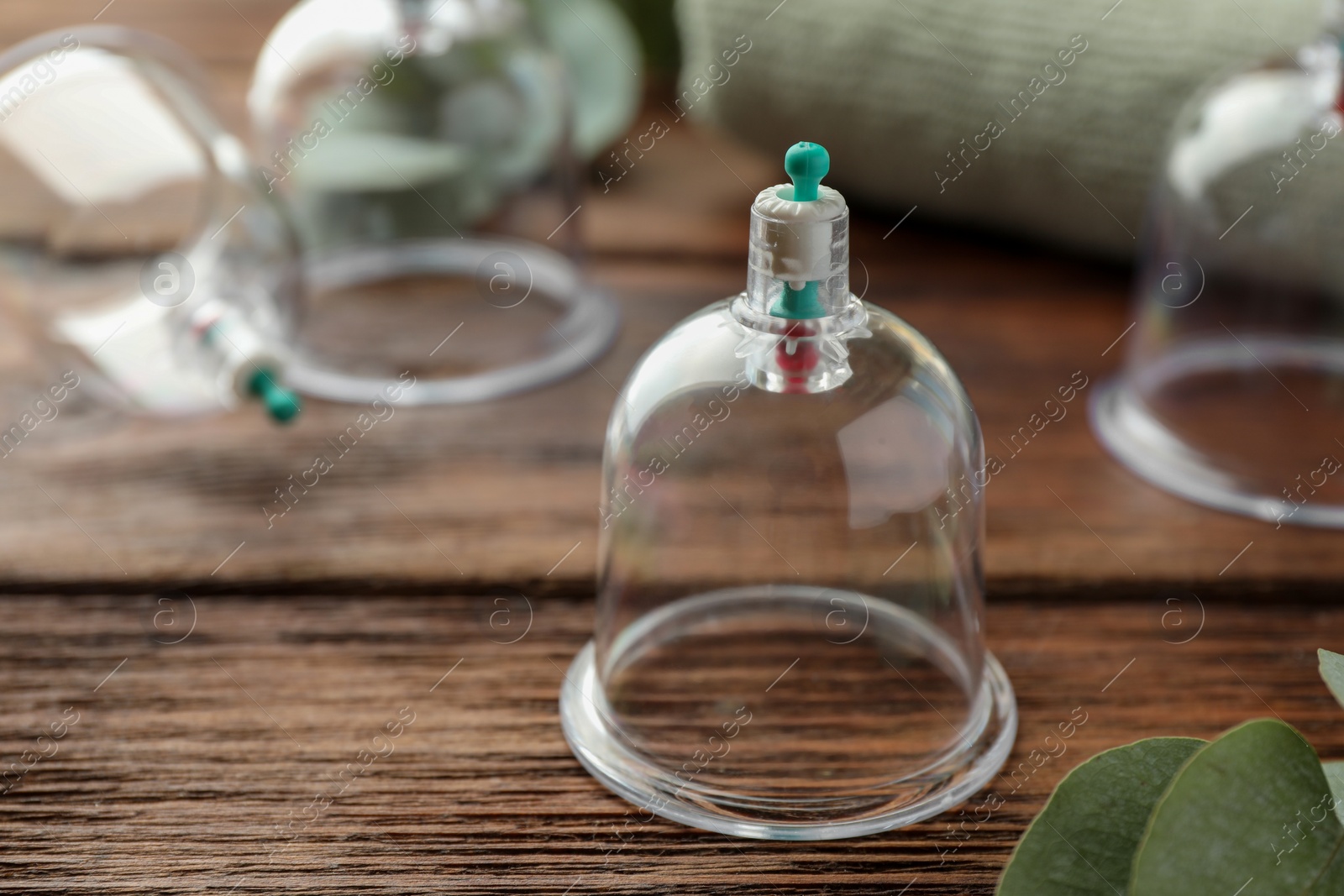 Photo of Cupping therapy. Plastic cup on wooden table, closeup. Space for text