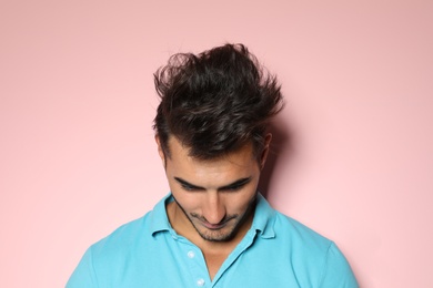 Photo of Young man with trendy hairstyle posing on color background