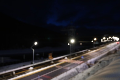 Photo of Blurred view of road with snow on sides at night