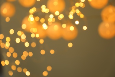 Blurred view of gold lights on dark background. Bokeh effect