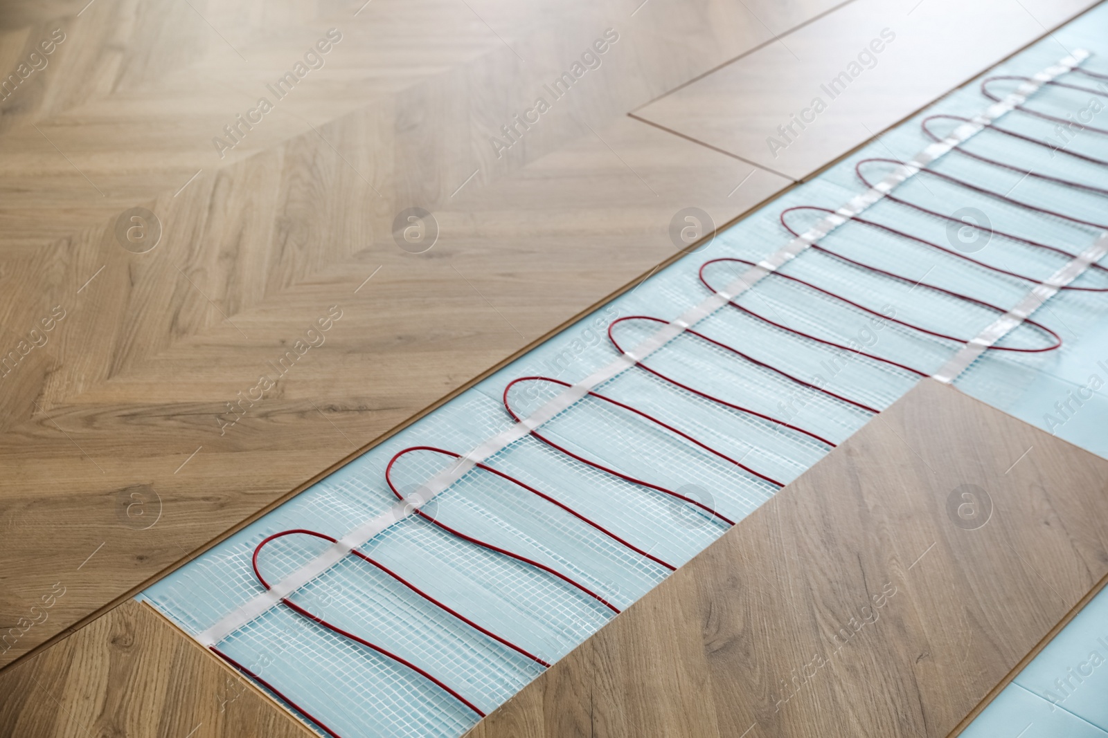 Photo of Installation of modern underfloor trace heating system indoors