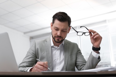 Businessman working with documents at table in office