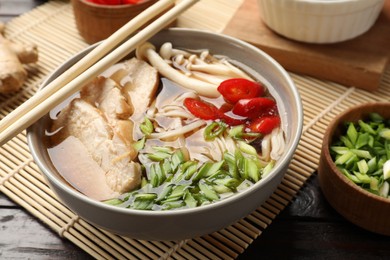 Photo of Delicious ramen with meat and ingredients on wooden table, closeup. Noodle soup