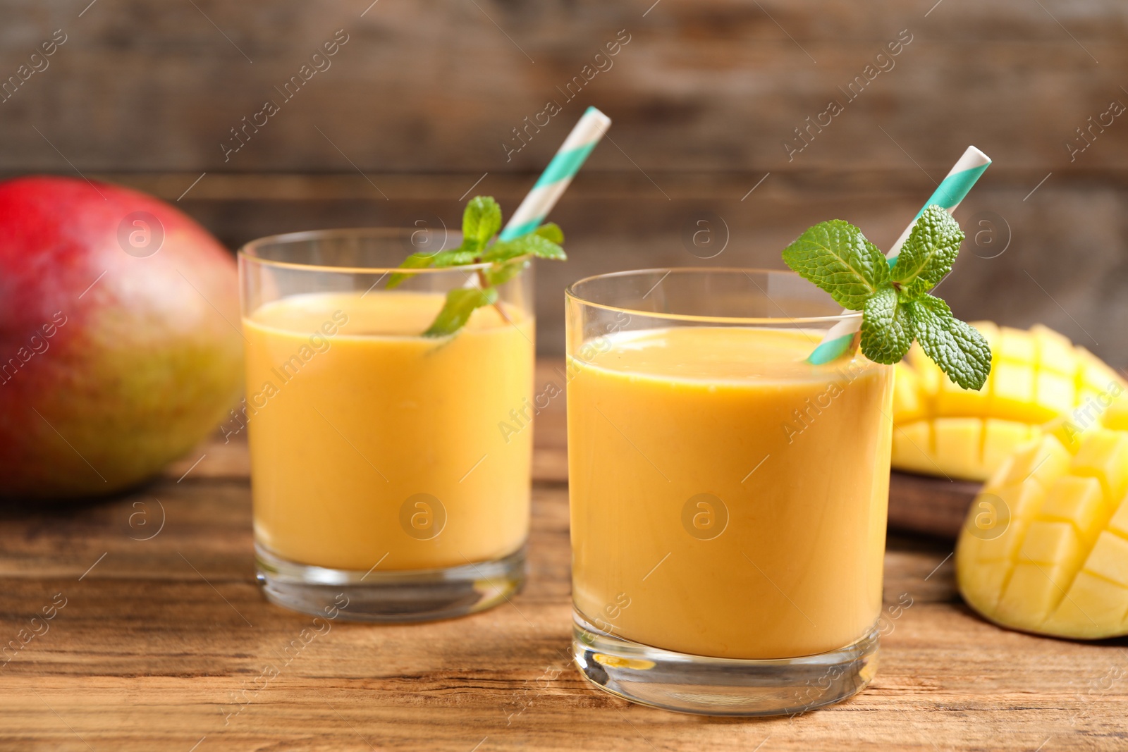 Photo of Fresh delicious mango drink on wooden table