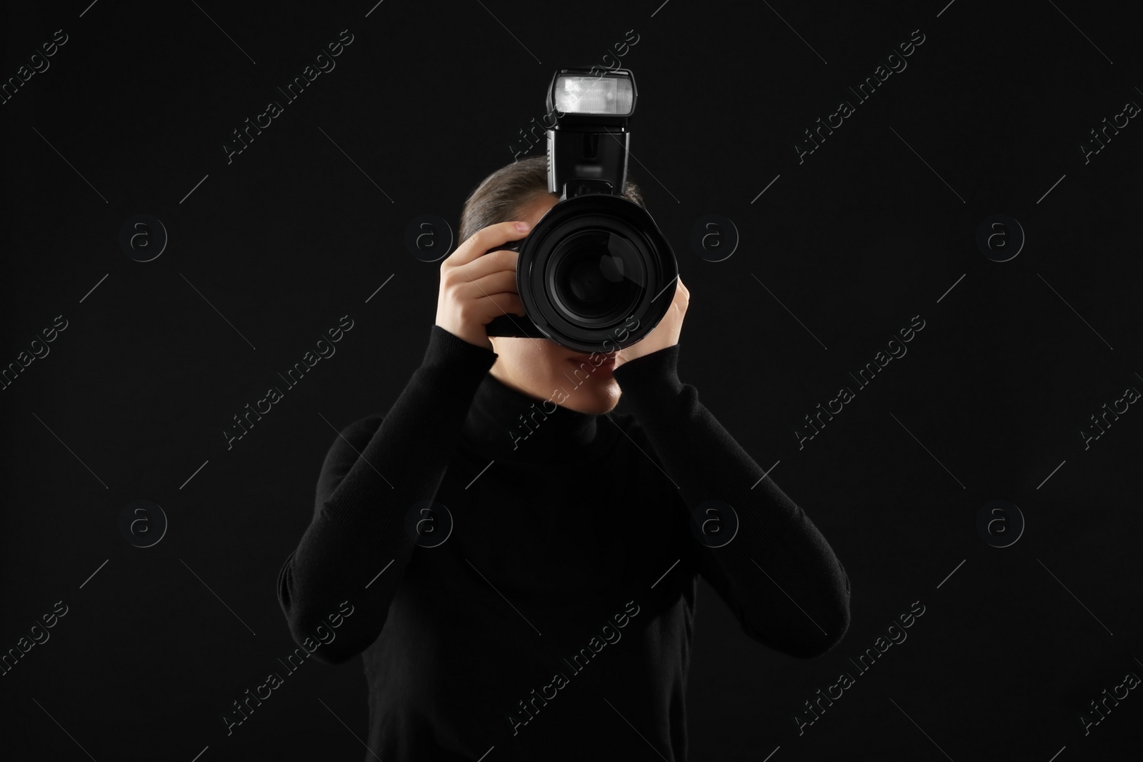 Photo of Professional photographer taking picture on black background