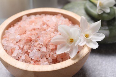 Photo of Spa composition with sea salt and flowers on light grey table, closeup