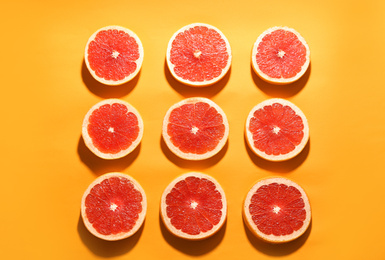 Photo of Flat lay composition with tasty ripe grapefruit slices on orange background