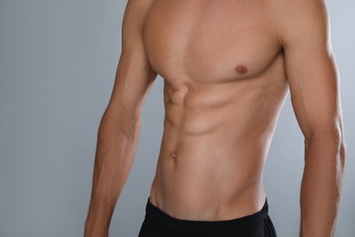 Photo of Shirtless man with slim body on grey background, closeup