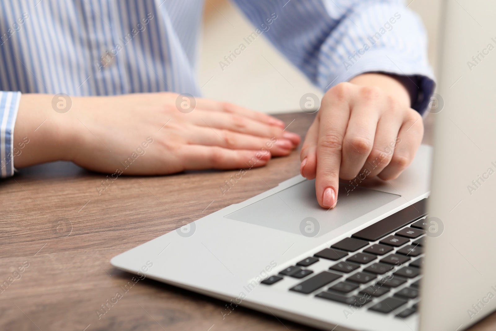 Photo of E-learning. Woman using laptop during online lesson at table indoors, closeup