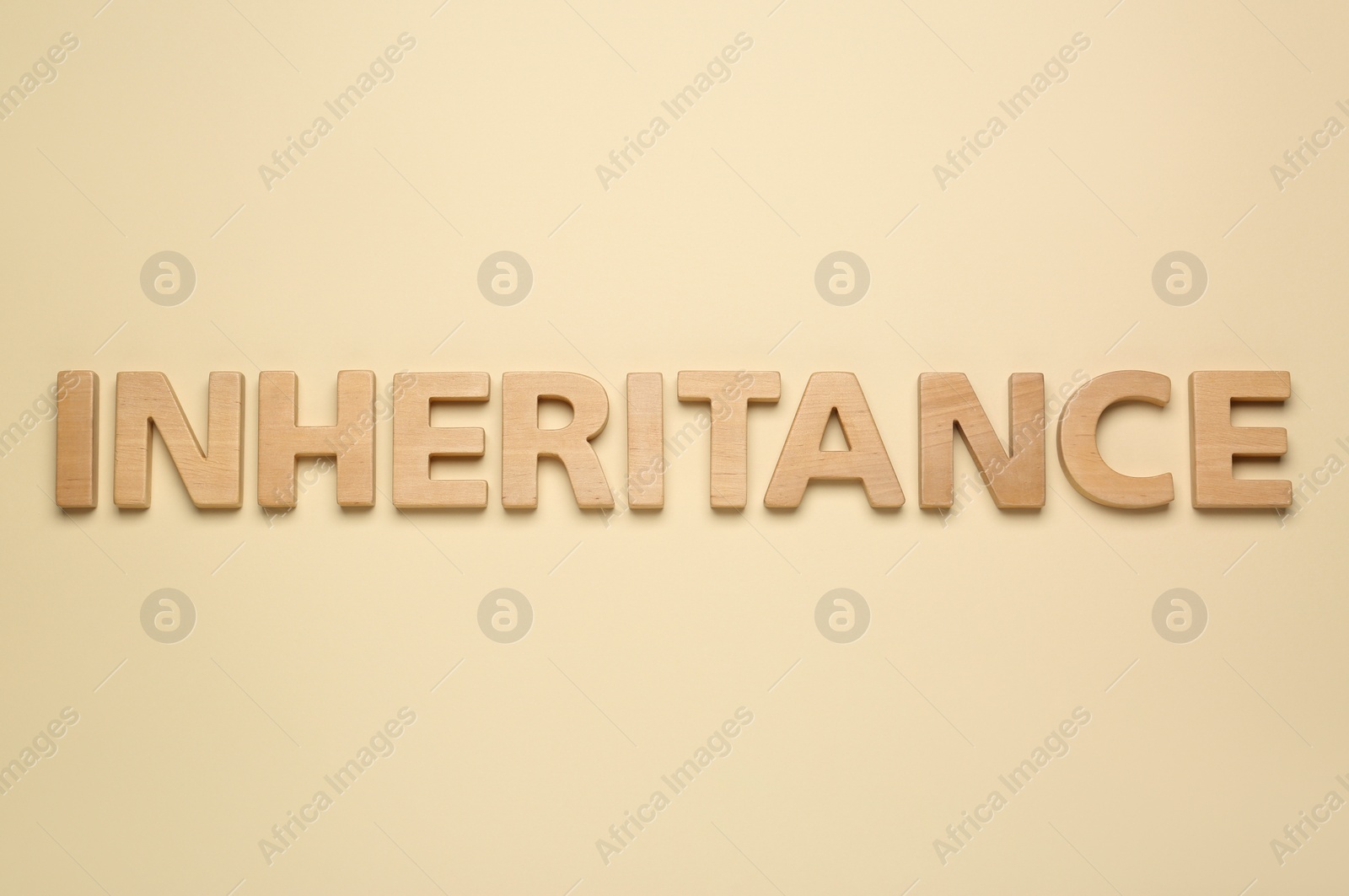 Photo of Word Inheritance made with wooden letters on beige background, flat lay