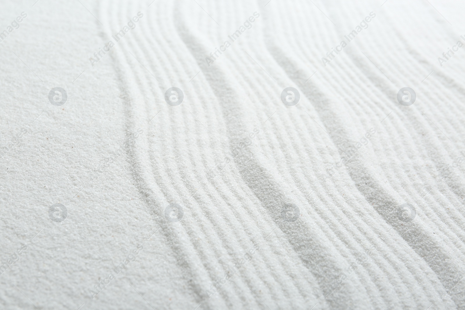 Photo of Zen rock garden. Wave pattern on white sand, closeup