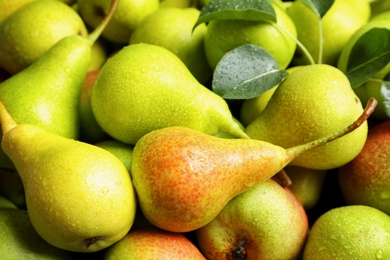 Fresh ripe pears with leaves as background