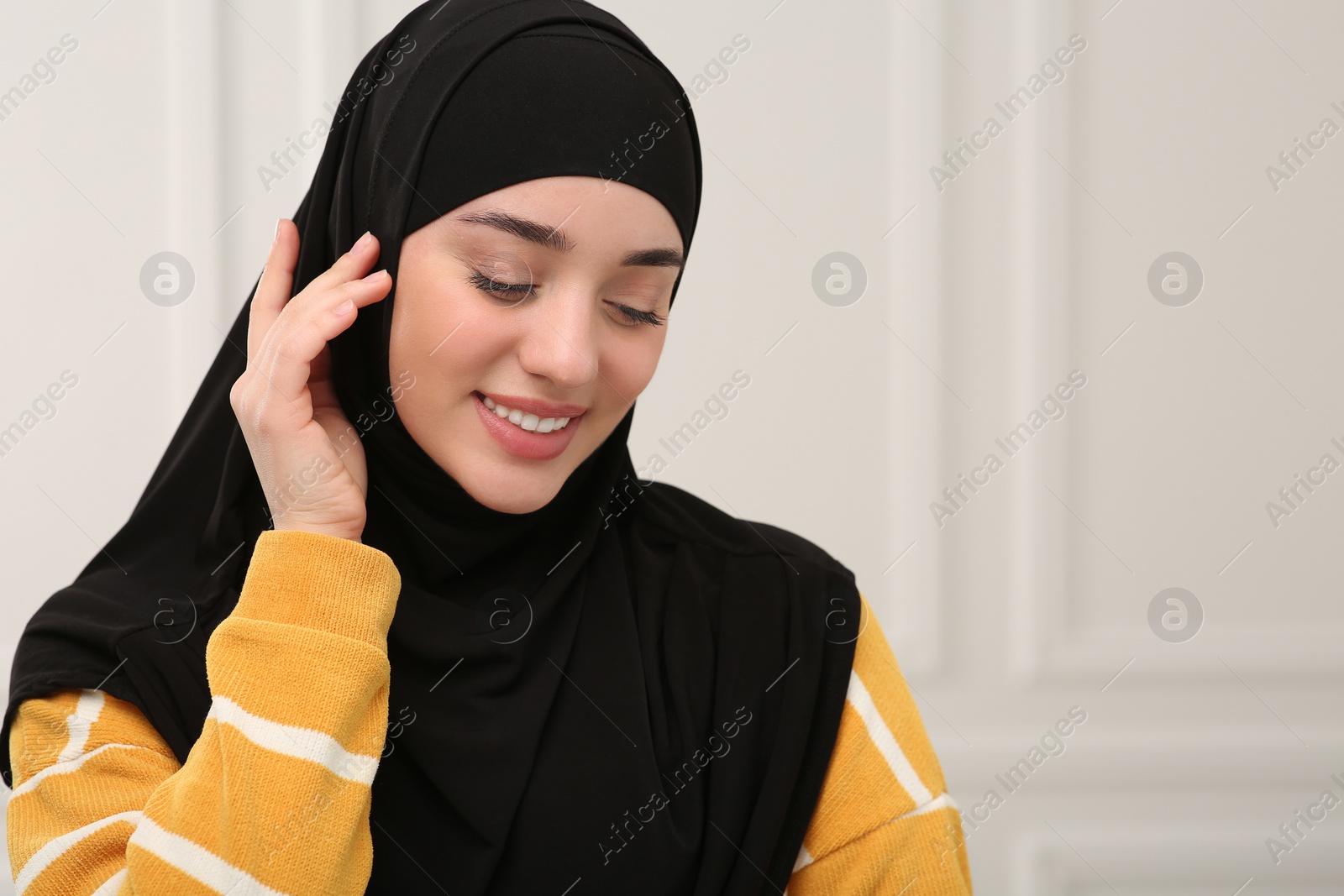 Photo of Beautiful Muslim woman wearing black hijab indoors