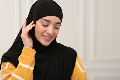 Photo of Beautiful Muslim woman wearing black hijab indoors
