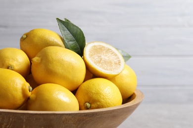 Photo of Many fresh ripe lemons on light grey table, closeup