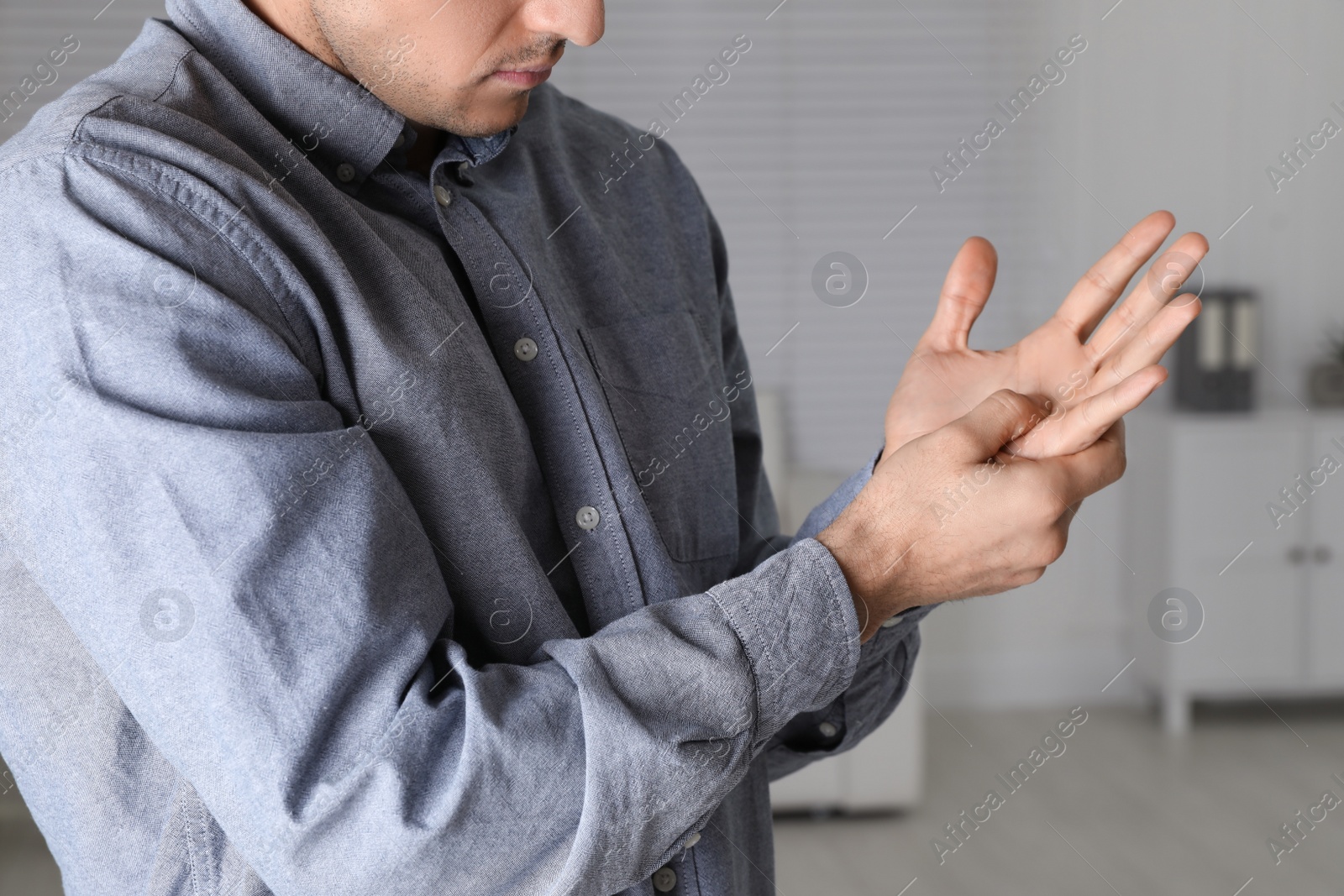 Photo of Man suffering from trigger finger at home, closeup