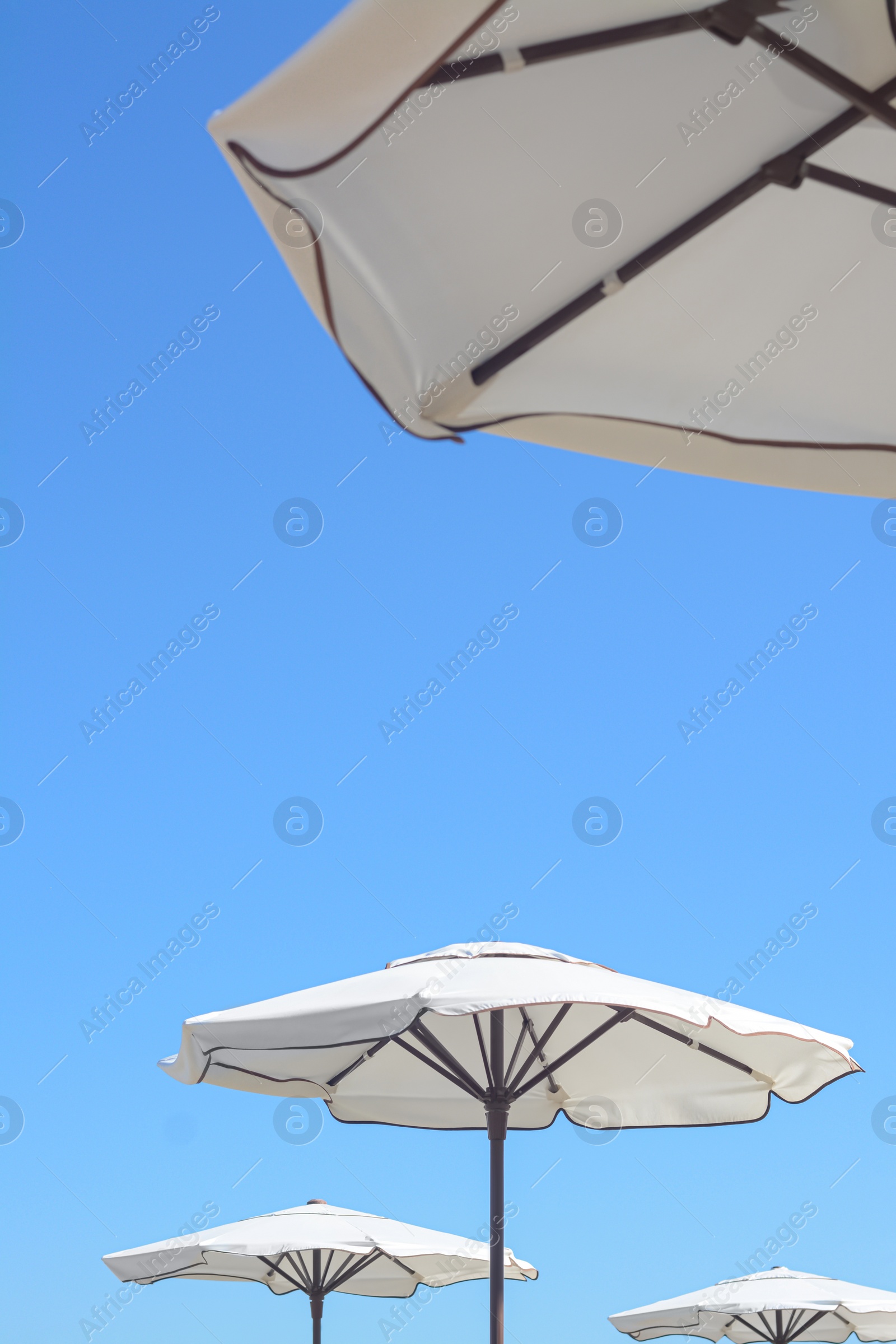 Photo of Beautiful white beach umbrellas against blue sky