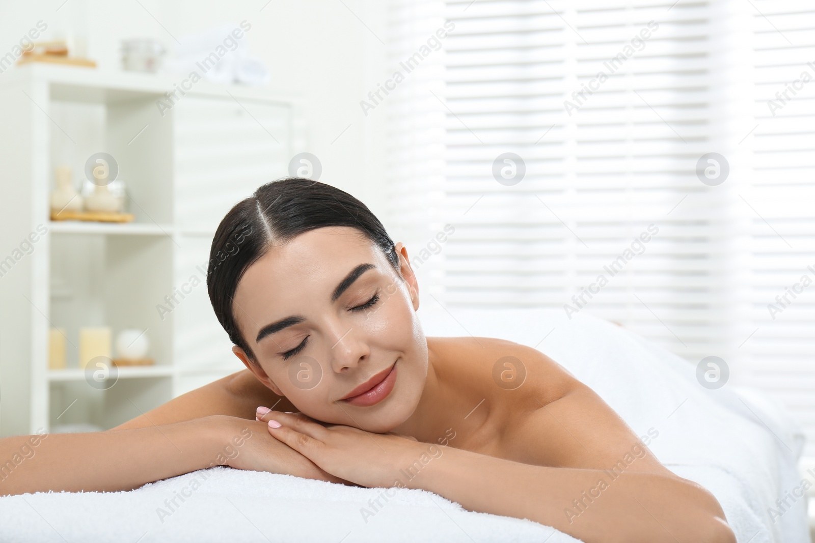 Photo of Beautiful young woman relaxing in spa salon