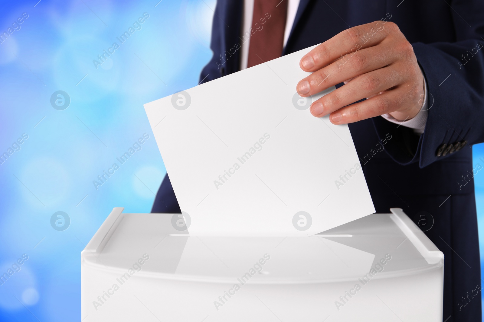 Image of Man putting his vote into ballot box on color background, closeup