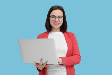 Photo of Happy young intern with laptop on light blue background