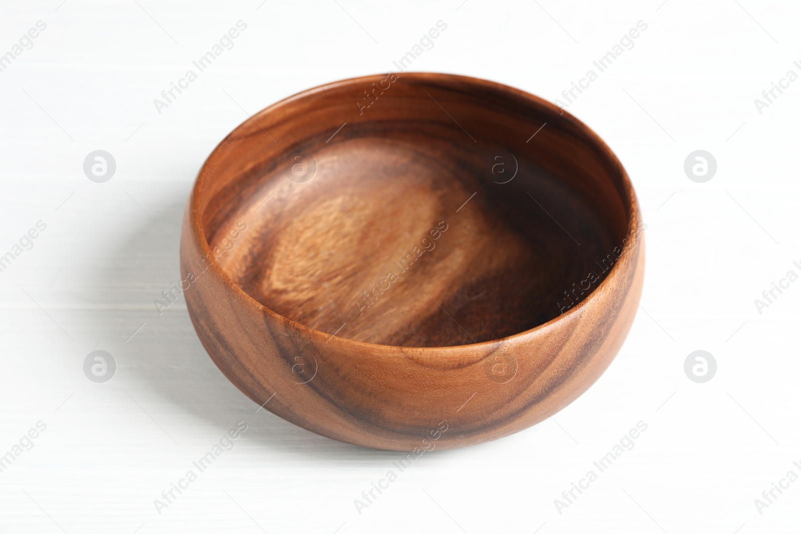 Photo of Empty clean wooden bowl on white table, closeup