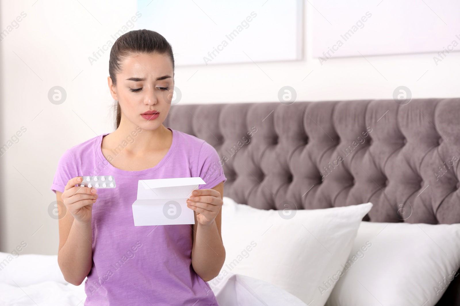 Photo of Beautiful young woman with pills at home