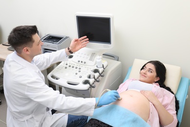 Photo of Young pregnant woman undergoing ultrasound scan in clinic