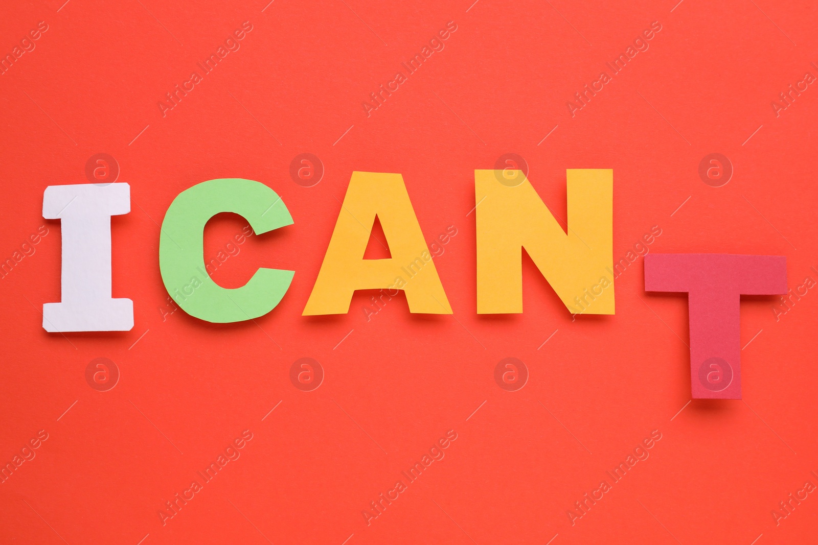 Photo of Motivation concept. Changing phrase from I Can't into I Can by removing paper letter T on red background, top view